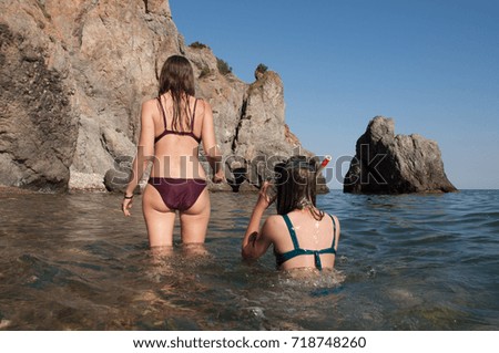 A girl in a swimsuit is resting and bathing on the sea in the summer. Beach in Crimea, Sevastopol