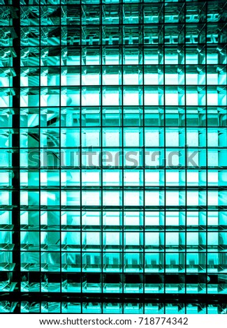 Turquoise blue color metal mesh with a square pattern on a bright lamp with gradient effect , close-up of movie illuminant against black background