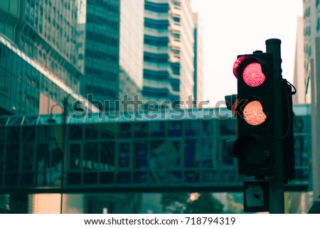 Traffic lights at 4 separate red lights. The back is a busy city view. Through coloring In Hong Kong