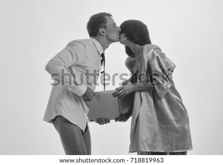 young kissing couple of handsome man or businessman and pretty woman or girl working on portable laptop or computer in shirt, gown and tie isolated on white background