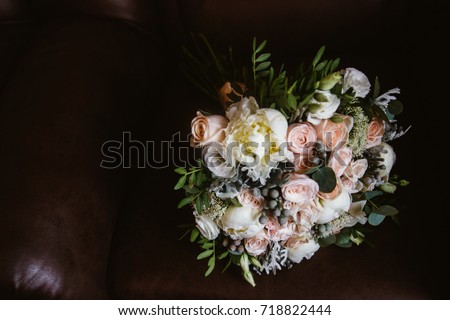 on the black sofa is a bridal bouquet of stylish, wedding details Royalty-Free Stock Photo #718822444