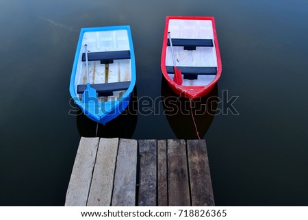 Two boats floating on the smooth surface of the water.