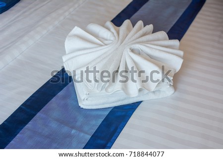 Towel Design : Bath Towel folded design on flower shape on bed sheet in bedroom at luxury hotel.