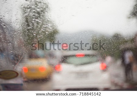 soft focus rain drop on car window, blurry of traffic light and cars were stoped