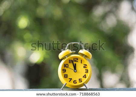 Retro alarm clock with five minutes to twelve o'clock.