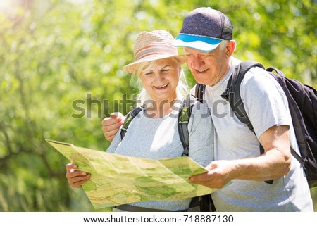 Senior couple reading map on country walk
