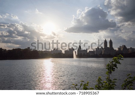 Buildings in Manhattan and lake at Central Park before sunset