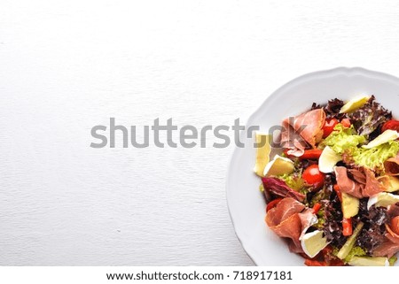 Vegetable salad and diced meat. On a wooden background. Top view. Free space.