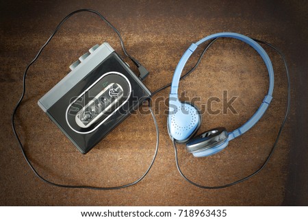 Vintage walkman and headphones on the wooden background Royalty-Free Stock Photo #718963435
