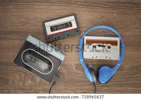 Vintage walkman, cassete and headphones on the wooden background Royalty-Free Stock Photo #718965637
