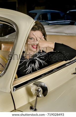 fashionable woman sitting in retro car cabriolet