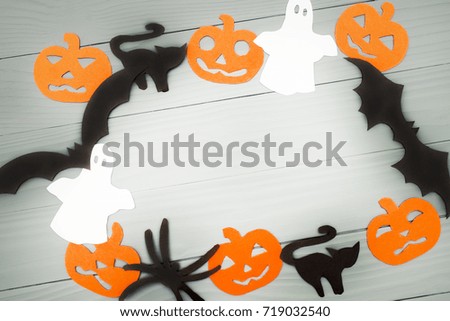 Halloween holiday background made of frame with pumpkins, bats, cats, spiders and ghosts cut paper on gray board. Copy space. Light up