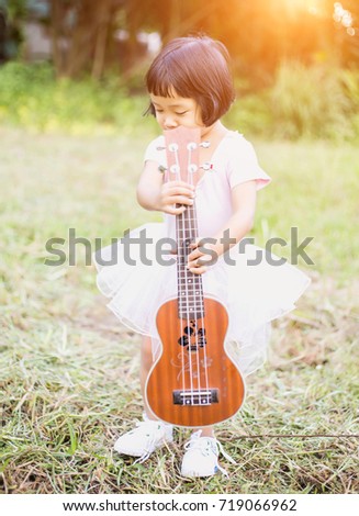 Young girl playing ukulele