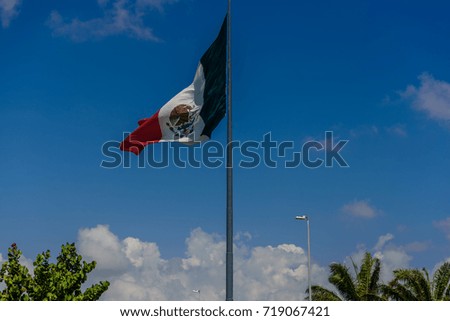 Giant mexican flag flies in the wind in Cancun. Shot in Yucatan, Mexico