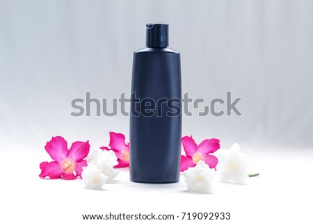 Black cosmetic, shampoo or perfume bottle - Mock up for your design - beautiful flowers and vintage filter background 