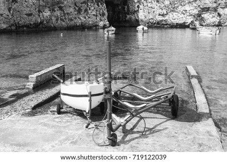 Boat on the trolley for launching on the water. The Inland Sea is a lagoon of seawater on the island of Gozo linked to the Mediterranean Sea through a narrow natural arch. Black and white picture