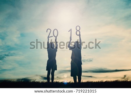 Silhouette of children holding 2018 word at sky sunset background, concept happy new year Royalty-Free Stock Photo #719221015