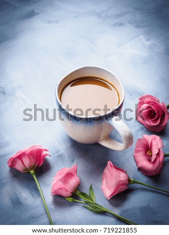 Mug of coffee and pink flowers on blue background. Festive mother valentine day greeting card