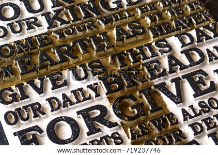 Word of the Lord's Prayer on the old  black weathered wooden plank background. Close-up.