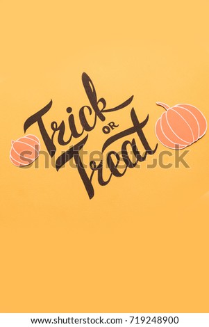 Halloween theme phrase in frame of pumpkins and bats on orange background