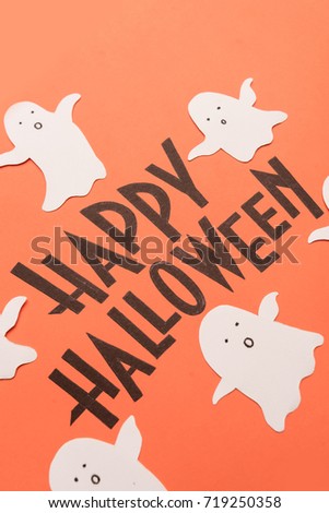 Black typeface phrase for halloween logo with ghosts handwritten on orange background