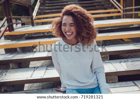 Curly haired girl with freckles in blank grey sweatshirt on the street. Mock up. Royalty-Free Stock Photo #719281321