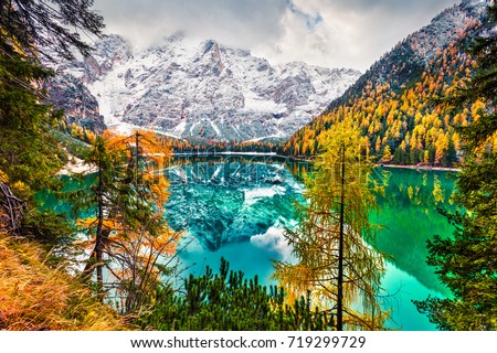 First snow on Braies Lake. Colorful autumn landscape in Italian Alps, Naturpark Fanes-Sennes-Prags, Dolomite, Italy, Europe. Beauty of nature concept background.  Royalty-Free Stock Photo #719299729