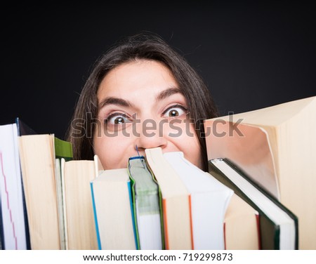 College student surrounded by books in close-up  having tears in her eyes