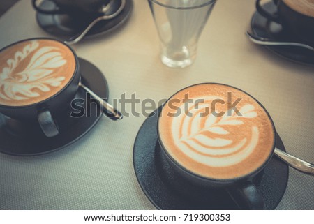 Cups of coffee on the table, latte art. vintage style effect picture.
