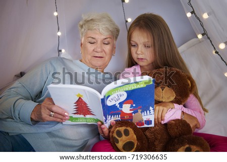 Granddaughter with grandmother watching a picture book