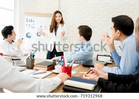 Asian business woman leader in a meeting with her multi-ethnic colleagues at the office presenting sales data or forecast for a project Royalty-Free Stock Photo #719312968