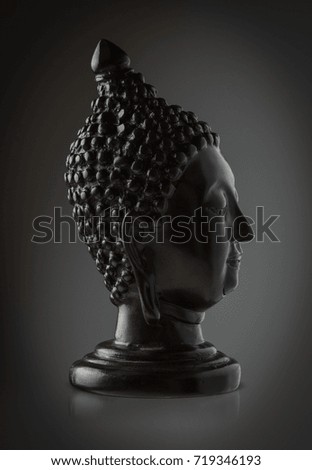 Statue of Buddha head black. isolated dark background.