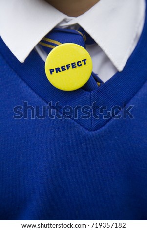 Young person in blue school uniform with a prefect badge Royalty-Free Stock Photo #719357182