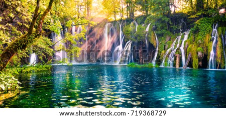 Last sunlight lights up the pure water waterfall on Plitvice National Park. Colorful spring panorama of green forest with blue lake. Great countryside view of Croatia, Europe.  Royalty-Free Stock Photo #719368729
