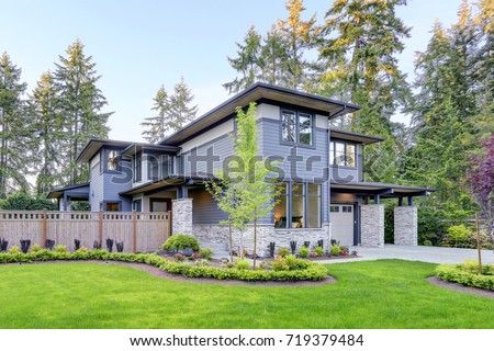 Luxurious new home with curb appeal. Trendy grey two-story mixed siding exterior in Bellevue with a hip roof and large picture windows. Northwest, USA