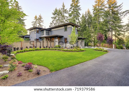 Luxurious new home with curb appeal. Trendy grey two-story mixed siding exterior in Bellevue with well manicured front yard and asphalt driveway. Northwest, USA