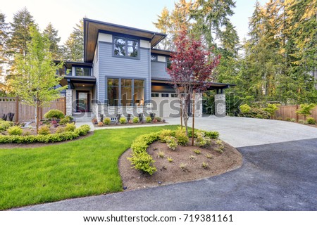 Luxurious new home with curb appeal. Trendy grey two-story mixed siding exterior in Bellevue with a hip roof and large picture windows. Northwest, USA