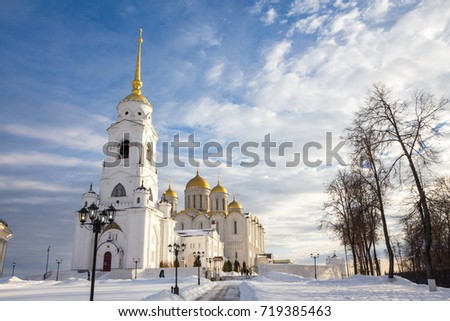 Big white cathedral with golden domes on a background of a cloudy blue sky