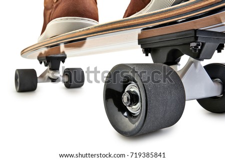 Dynamic rear view of a Black and wooden skate board and brown leathers shoes isolated on a white background with clipping path