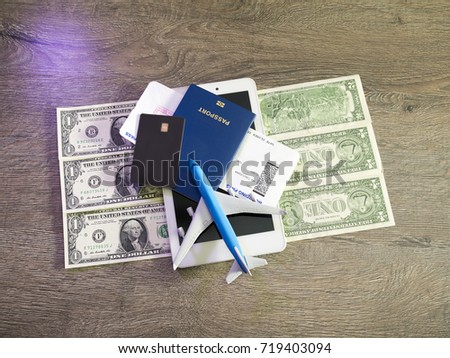 travel concept with tablet, credit cards and flight tickets on dark table