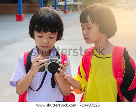 Asian pretty two girls children in student uniform holding and take a photo on morning 