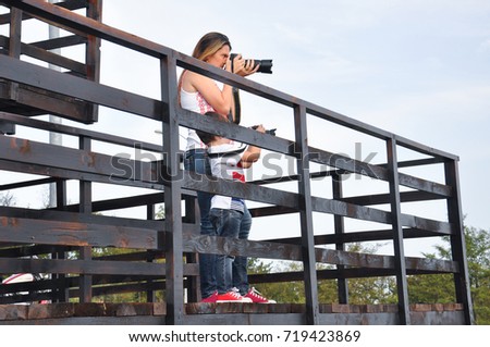 Mom and son make photos with digital camera. Woman photographer taking photo together with her son