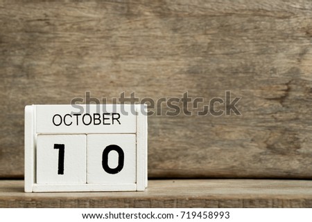 White block calendar present date 10 and month October on wood background