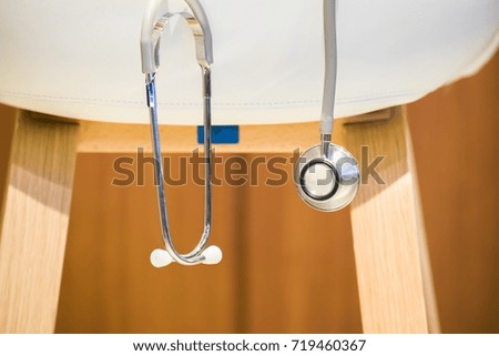 White chair with stethoscope on home office blurry background.using wallpaper for education, medical image.Take note of the product for book with paper object, concept or copy space.