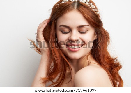  joyful, young, beautiful woman with closed eyes on head accessory on light background portrait                              