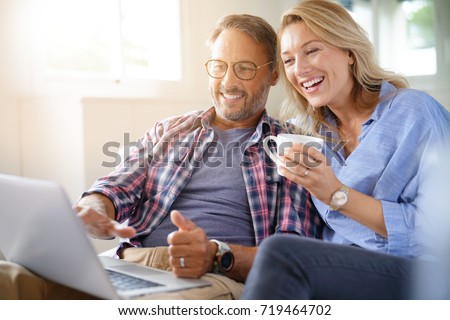 Mature couple connected on internet with laptop
