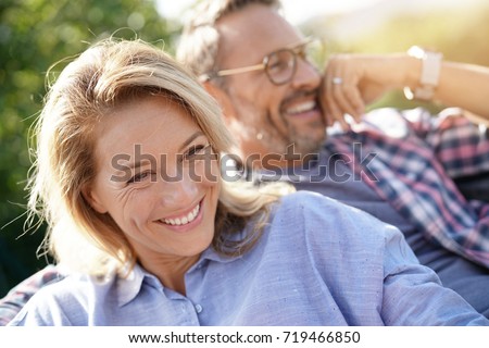 Portrait of mature couple relaxing in outdoor sofa Royalty-Free Stock Photo #719466850