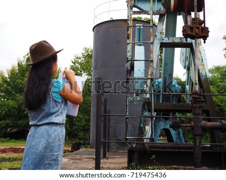 Little girl with Oil Pump Jack (Sucker Rod Beam) on tropical forest background