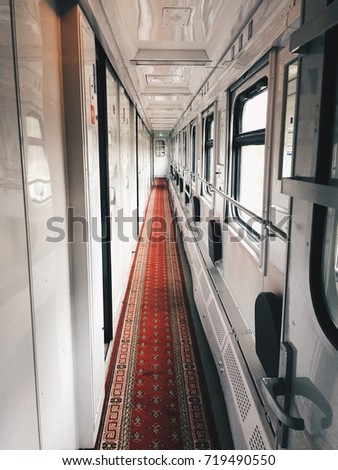 Inside the train. Long wagon with red carpet. Travel concept Royalty-Free Stock Photo #719490550