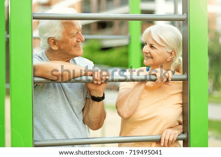Senior couple exercising at outdoor gym
